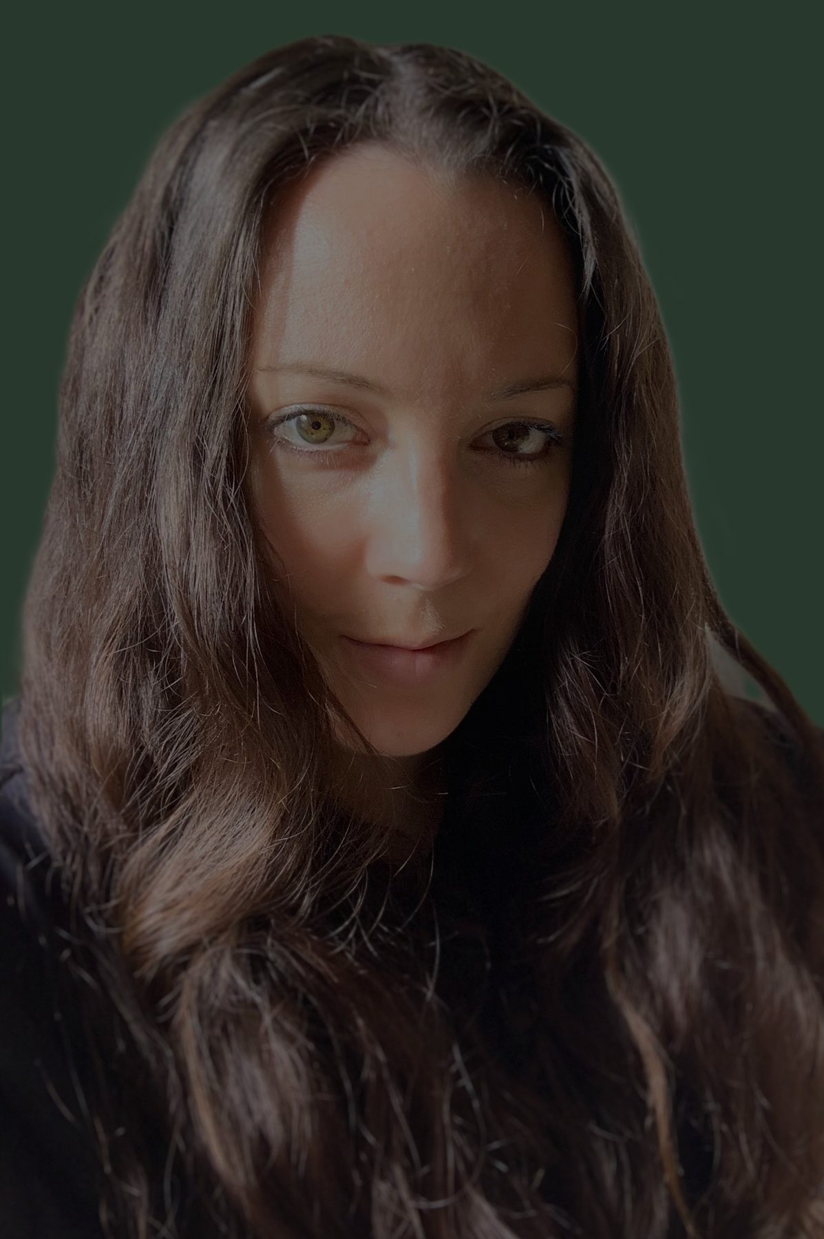 Camilla, founder of Mills, against a deep green wall