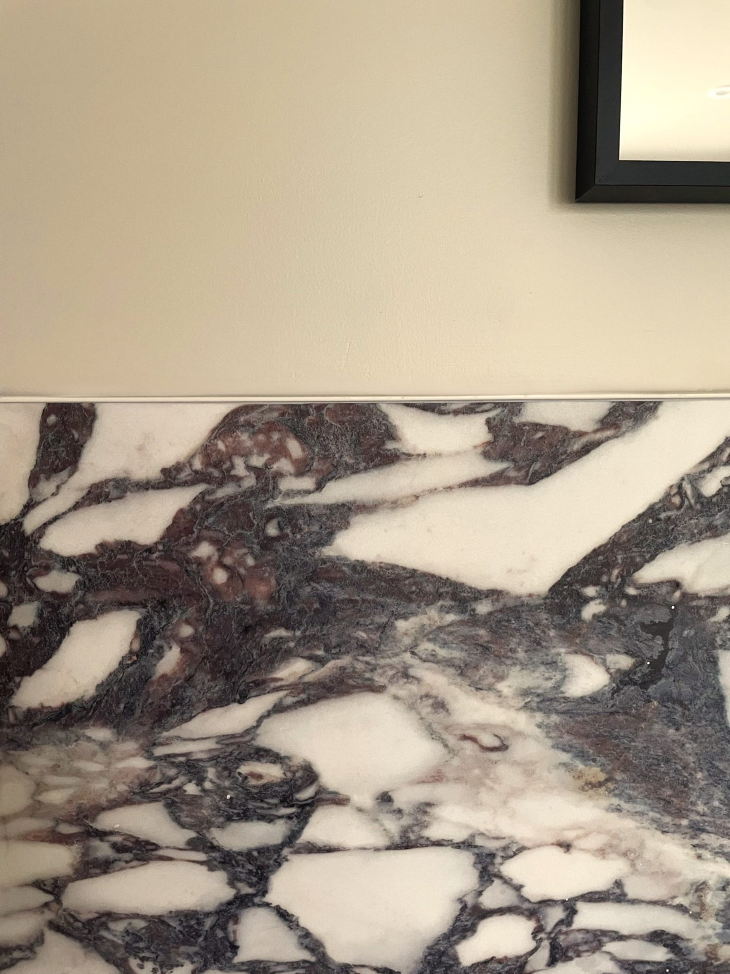 Close-up of Calacatta Viola marble wall tiles with deep purple veining