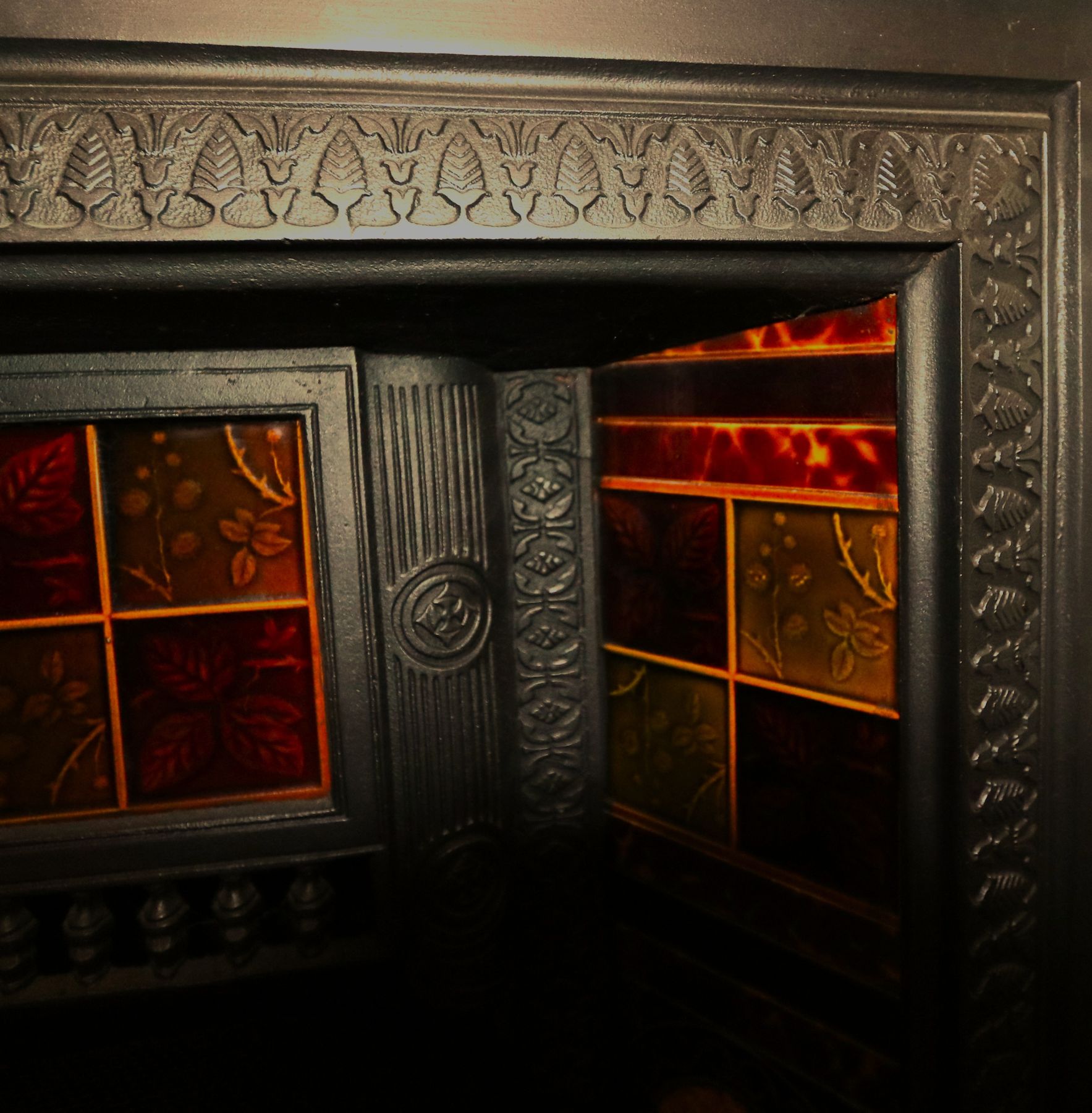 A Victorian tiled fireplace with ruby glass tiles