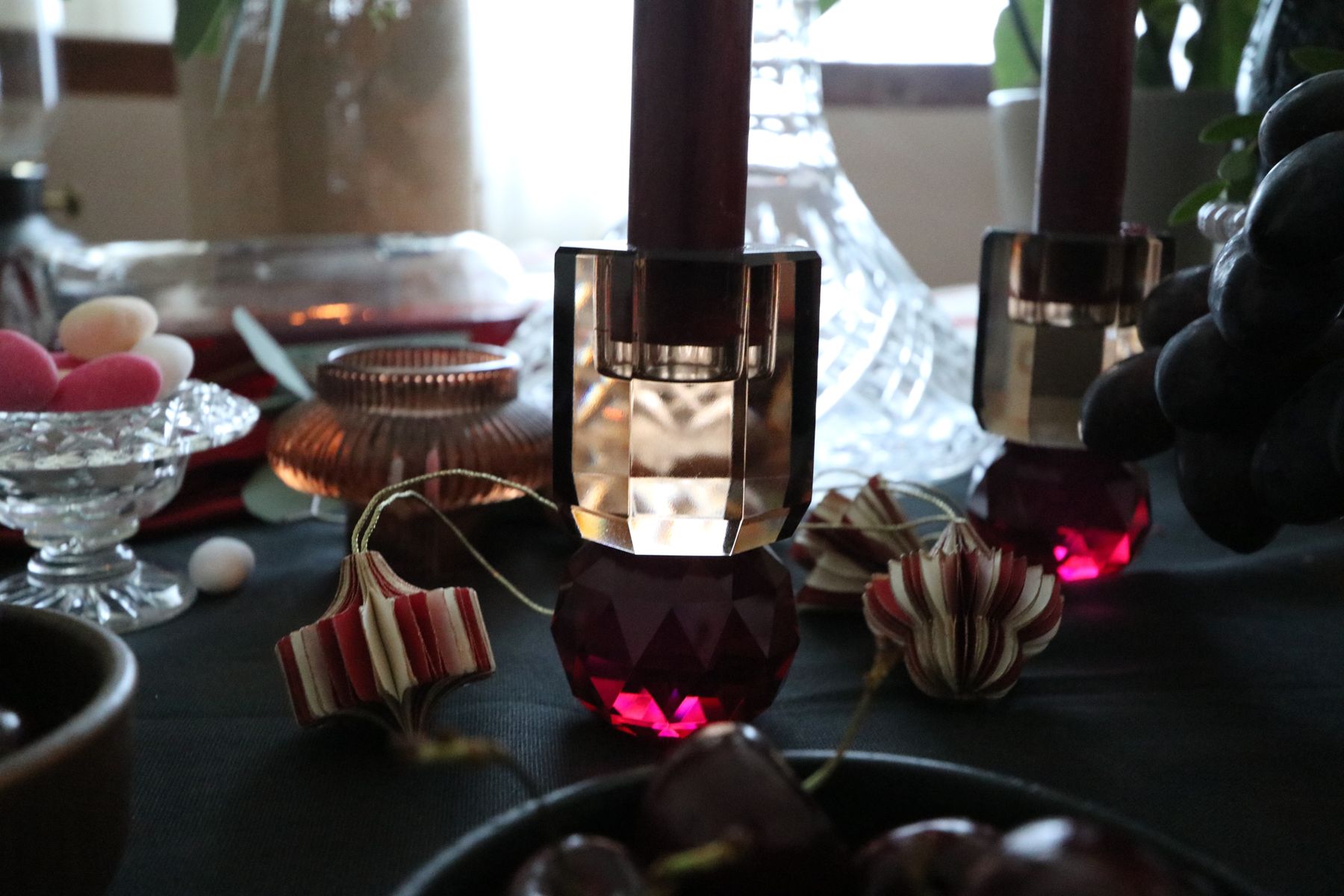 A crystal candle holder and pink glass tealight on the table
